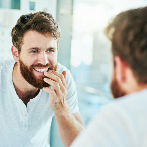 man smiling into mirro