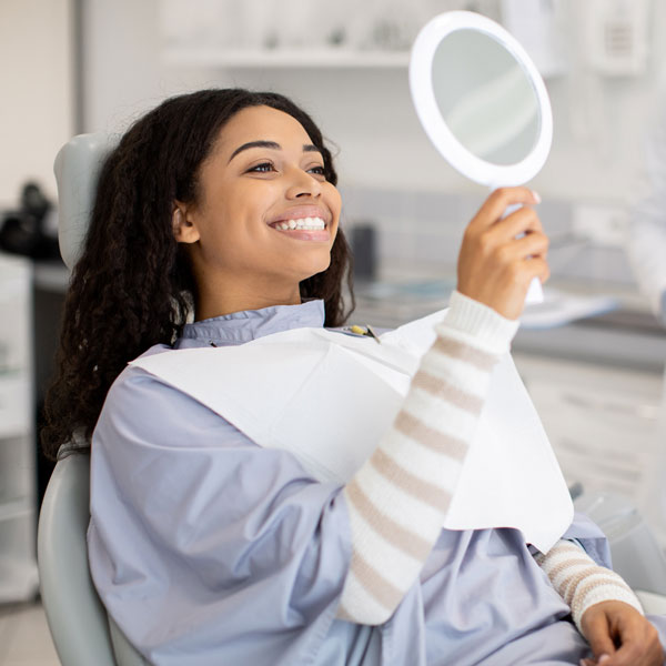 woman smiling into mirror